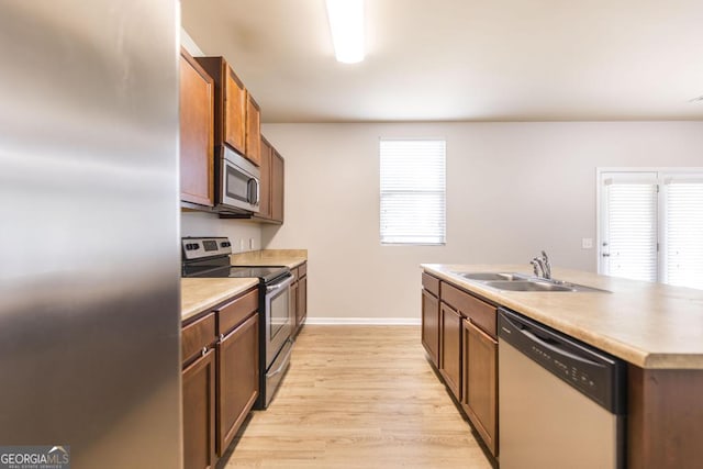243 Flowing Meadows Dr, Kathleen, GA 31047 - kitchen with appliances with stainless steel finishes, healthy amount of natural light, light wood finished floors, and a kitchen island with sink