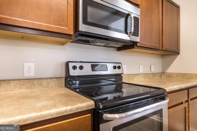 243 Flowing Meadows Dr, Kathleen, GA 31047 - kitchen featuring appliances with stainless steel finishes, light countertops, and brown cabinets