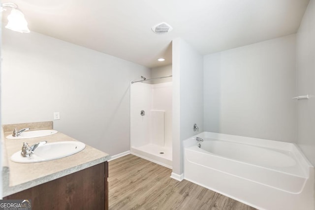 243 Flowing Meadows Dr, Kathleen, GA 31047 - full bathroom featuring a garden tub, wood finished floors, a shower, and double vanity