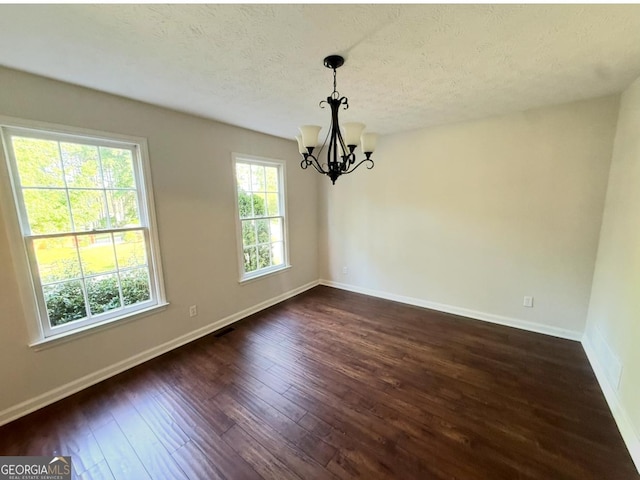 1875 Tree Brooke Ln, Snellville, GA 30078 - unfurnished dining area with a chandelier, dark wood-style floors, and a textured ceiling