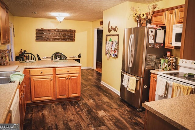 1665 Jackson Lake Rd, Mansfield, GA 30055 - kitchen with white appliances, a peninsula, dark wood-type flooring, a textured ceiling, and light countertops