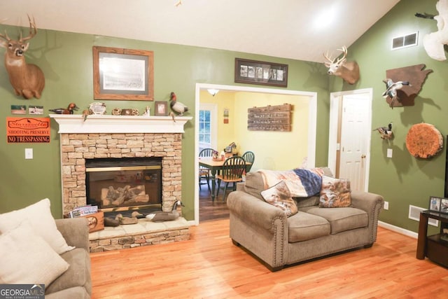 1665 Jackson Lake Rd, Mansfield, GA 30055 - living room with wood finished floors, a stone fireplace, and lofted ceiling