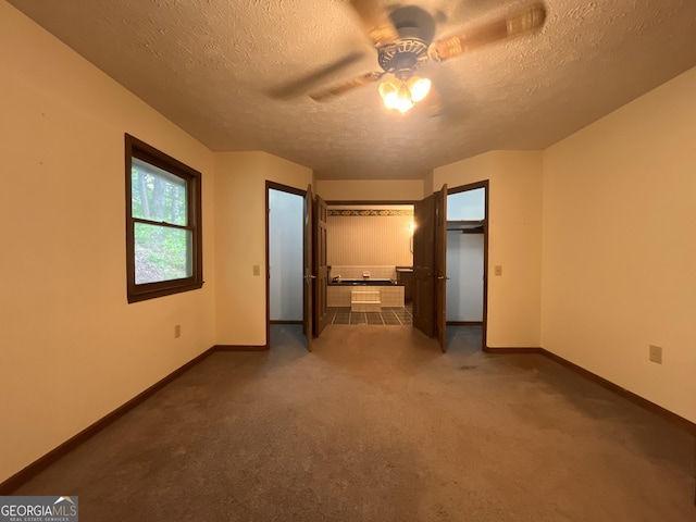 172 Fred Henry Ln, Clayton, GA 30525 - unfurnished bedroom with a textured ceiling, dark colored carpet, and a ceiling fan
