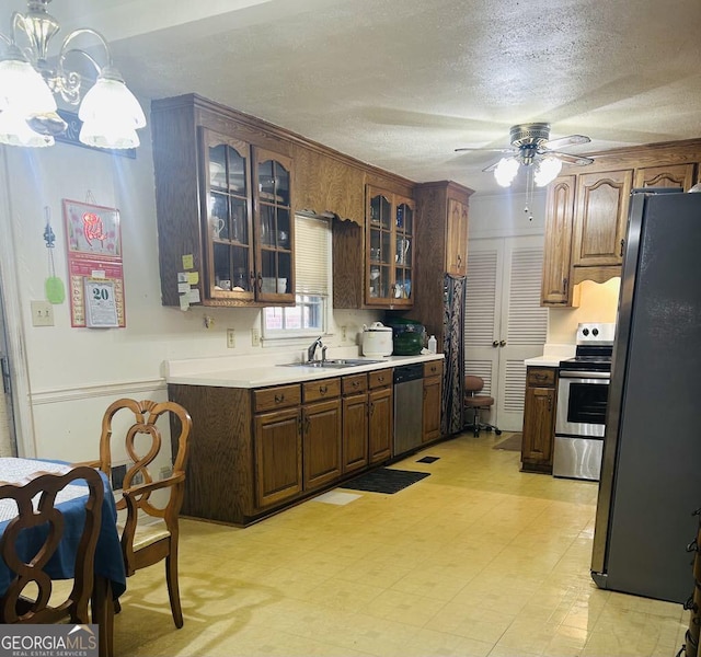 2235 Lyn Ct, Macon, GA 31206 - kitchen featuring stainless steel appliances, light countertops, a ceiling fan, glass insert cabinets, and a textured ceiling