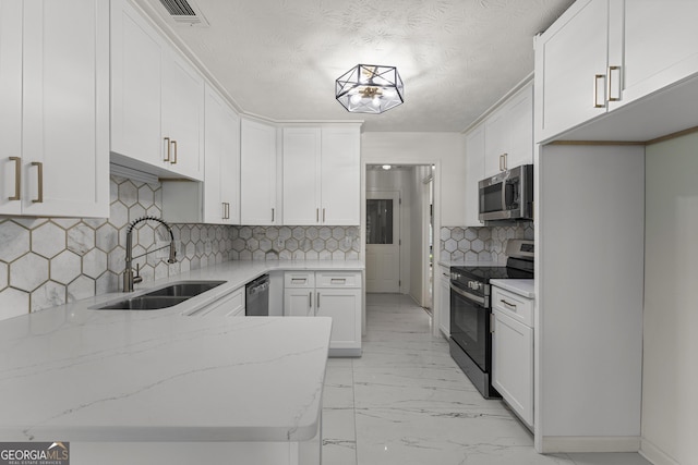 5437 Chatham Woods Ct, Columbus, GA 31907 - kitchen featuring stainless steel appliances, light stone counters, light marble finish flooring, white cabinets, and a peninsula