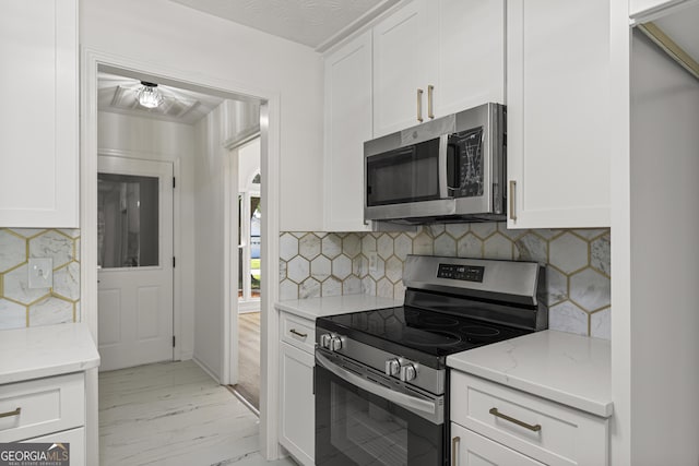 5437 Chatham Woods Ct, Columbus, GA 31907 - kitchen featuring stainless steel appliances, light marble finish flooring, light stone countertops, white cabinetry, and tasteful backsplash