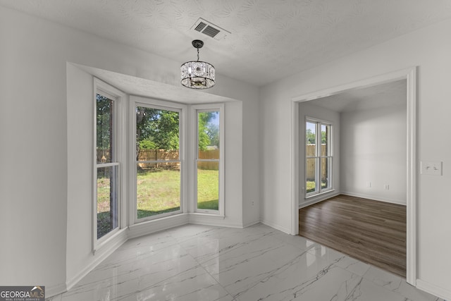 5437 Chatham Woods Ct, Columbus, GA 31907 - unfurnished dining area with marble finish floors, a chandelier, and a textured ceiling