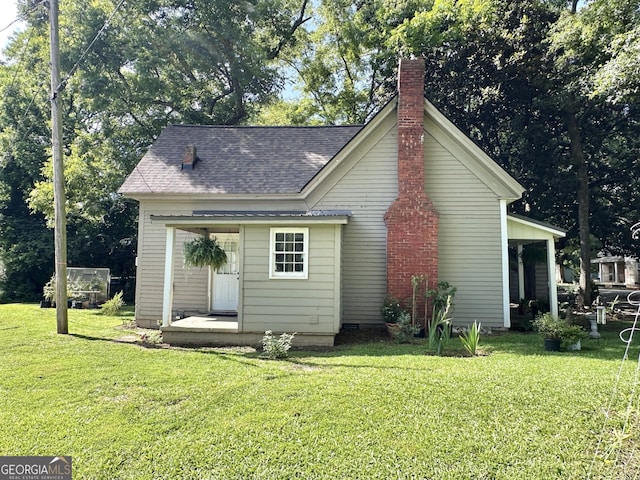 6192 Collins St NE, Covington, GA 30014 - rear view of property with a chimney, roof with shingles, and a yard