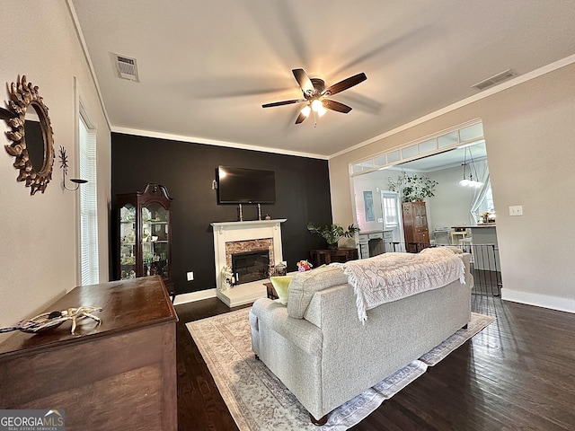 6192 Collins St NE, Covington, GA 30014 - living area with ceiling fan, wood finished floors, a fireplace with raised hearth, and ornamental molding