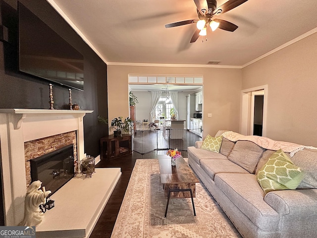 6192 Collins St NE, Covington, GA 30014 - living area with wood finished floors, a ceiling fan, a fireplace, and ornamental molding