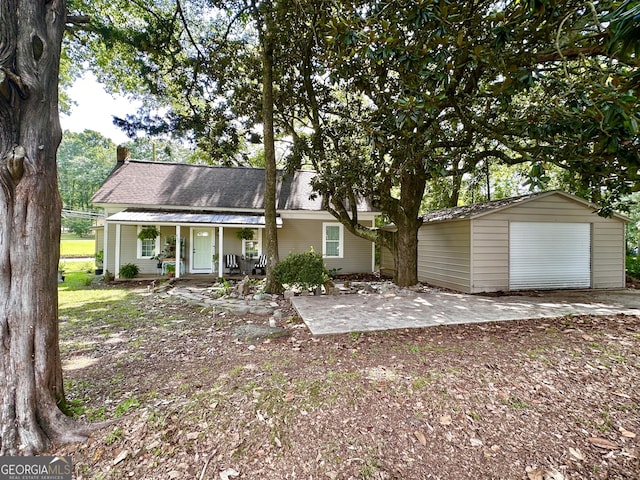 6192 Collins St NE, Covington, GA 30014 - rear view of property featuring a porch, a detached garage, a chimney, an outbuilding, and roof with shingles
