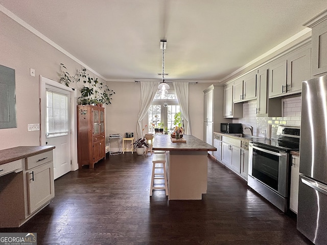 6192 Collins St NE, Covington, GA 30014 - kitchen featuring stainless steel appliances, backsplash, ornamental molding, a kitchen breakfast bar, and a kitchen island