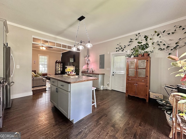 6192 Collins St NE, Covington, GA 30014 - kitchen with dark countertops, dark wood-style floors, electric panel, a center island, and a kitchen bar