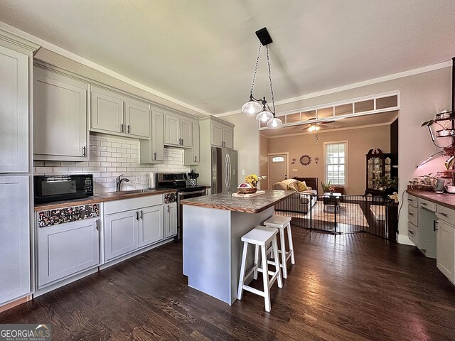 6192 Collins St NE, Covington, GA 30014 - kitchen with stainless steel appliances, dark wood-style floors, ornamental molding, backsplash, and a kitchen island