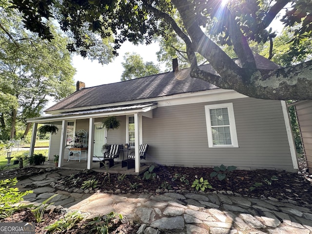 6192 Collins St NE, Covington, GA 30014 - view of front of property featuring a porch, a chimney, and a shingled roof