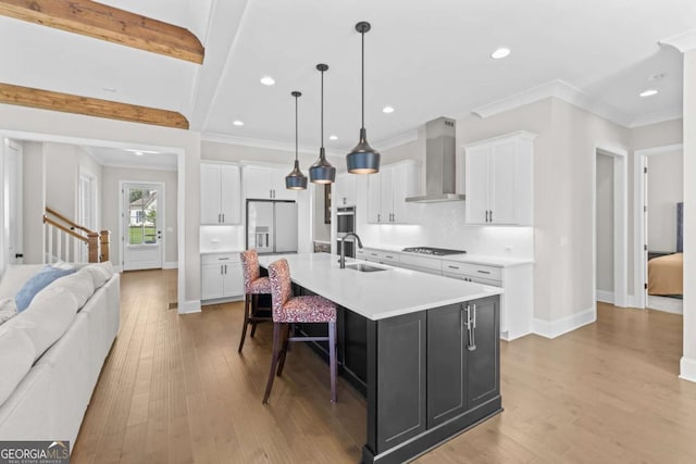 6080 Simone St, Acworth, GA 30101 - kitchen with wall chimney exhaust hood, gas cooktop, light countertops, light wood-style floors, and ornamental molding