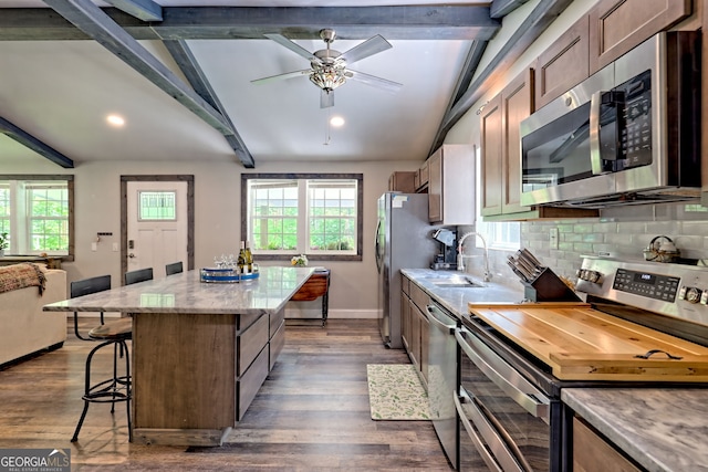 11 Hamilton Cir, Blairsville, GA 30512 - kitchen featuring stainless steel appliances, a center island, a kitchen breakfast bar, backsplash, and dark wood-type flooring