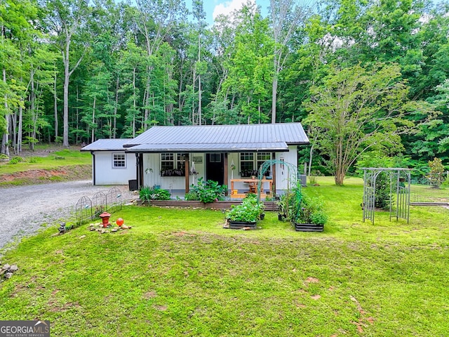 11 Hamilton Cir, Blairsville, GA 30512 - view of front facade featuring a front lawn, a metal roof, covered porch, driveway, and a vegetable garden