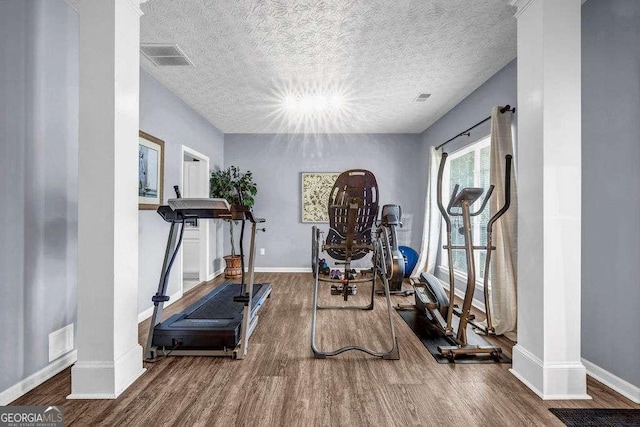 15 Saddlebrook Ct, Covington, GA 30016 - exercise room with wood finished floors, decorative columns, a textured ceiling, and a chandelier