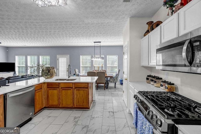 15 Saddlebrook Ct, Covington, GA 30016 - kitchen featuring appliances with stainless steel finishes, light marble finish flooring, light countertops, and healthy amount of natural light