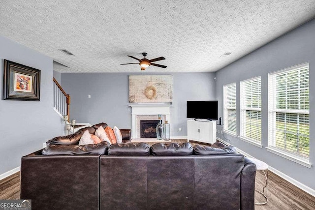 15 Saddlebrook Ct, Covington, GA 30016 - living room with wood finished floors, a ceiling fan, a fireplace, and a textured ceiling