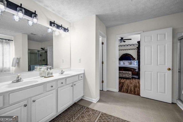 15 Saddlebrook Ct, Covington, GA 30016 - bathroom featuring a stall shower, double vanity, connected bathroom, a textured ceiling, and ceiling fan