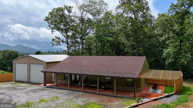1529 Cedar Vw, Hiawassee, GA 30546 - view of front of home with stone siding, a detached garage, covered porch, and a shingled roof