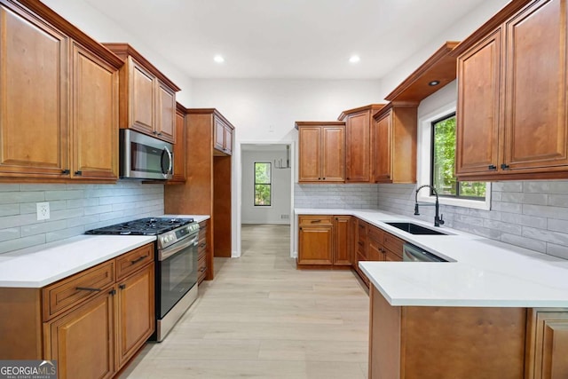 3292 Holly Mill Ct, Marietta, GA 30062 - kitchen featuring appliances with stainless steel finishes, brown cabinets, light countertops, a peninsula, and recessed lighting