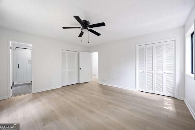 3292 Holly Mill Ct, Marietta, GA 30062 - unfurnished bedroom with multiple closets, wood finished floors, connected bathroom, and ceiling fan