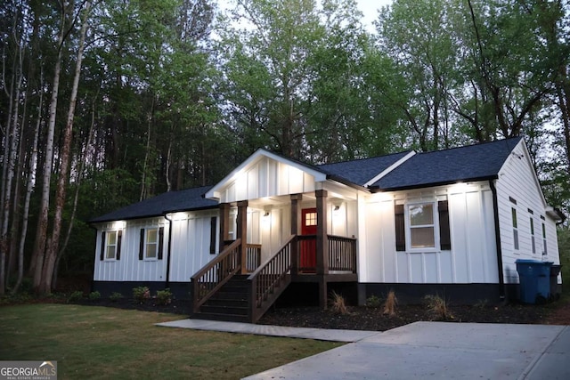 2798 Hutchins Rd, Lawrenceville, GA 30044 - view of front of property featuring board and batten siding, covered porch, a shingled roof, and a front yard