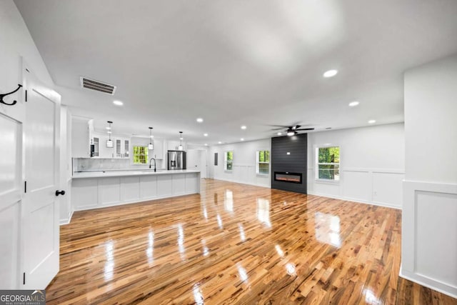 2798 Hutchins Rd, Lawrenceville, GA 30044 - unfurnished living room featuring ceiling fan, recessed lighting, light wood finished floors, plenty of natural light, and a wainscoted wall