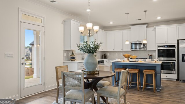 687 Edgar St Lot 83, Hampton, GA 30228 - kitchen featuring appliances with stainless steel finishes, backsplash, crown molding, white cabinetry, and light countertops