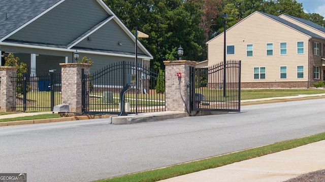 687 Edgar St Lot 83, Hampton, GA 30228 - view of asphalt road with sidewalks, street lights, curbs, and a gate