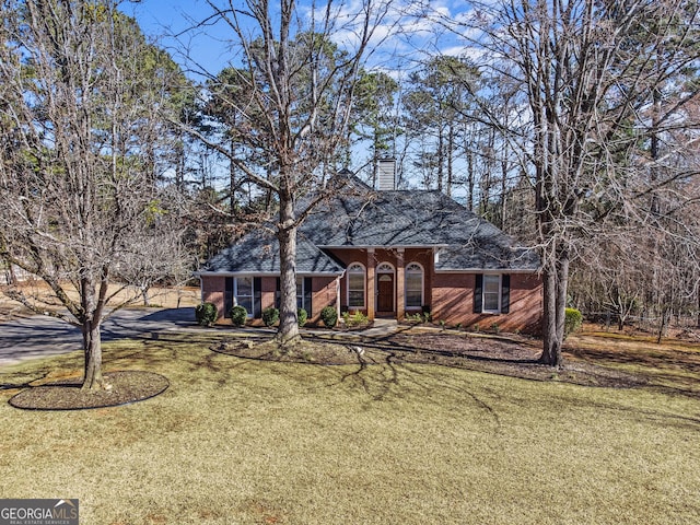 105 S Arcadia Dr, Bogart, GA 30622 - view of front facade featuring a front yard, brick siding, a chimney, and driveway
