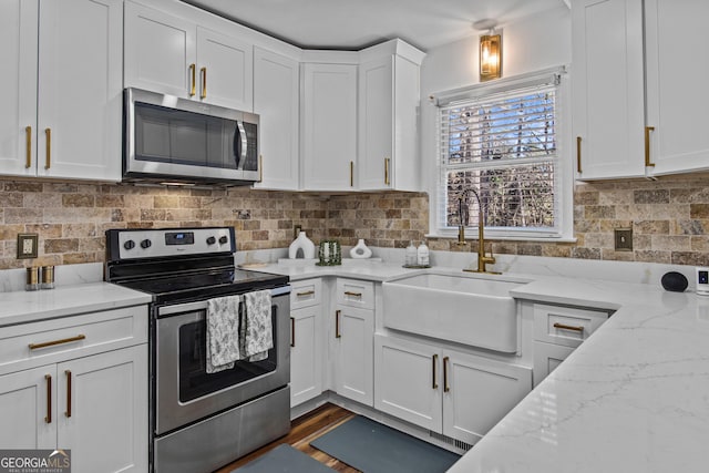 105 S Arcadia Dr, Bogart, GA 30622 - kitchen featuring stainless steel appliances, white cabinetry, decorative backsplash, and light stone counters