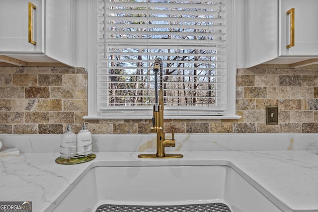 105 S Arcadia Dr, Bogart, GA 30622 - kitchen with white cabinetry, light stone counters, and backsplash