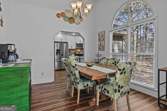 105 S Arcadia Dr, Bogart, GA 30622 - dining space featuring a chandelier, dark wood-style flooring, arched walkways, and a high ceiling
