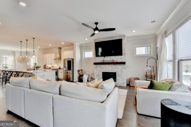 767 Farmstead Rd, Suwanee, GA 30024 - living area with crown molding, ceiling fan, a fireplace, wood finished floors, and recessed lighting