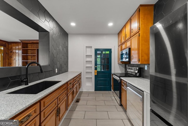 3105 Woodlawn Ave, Columbus, GA 31904 - kitchen featuring appliances with stainless steel finishes, tasteful backsplash, brown cabinets, light stone counters, and recessed lighting