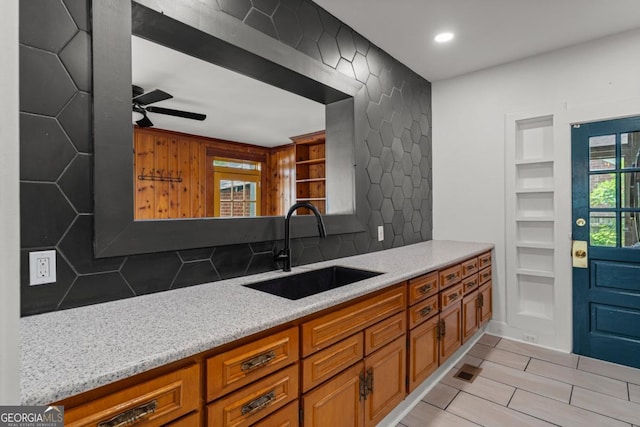3105 Woodlawn Ave, Columbus, GA 31904 - kitchen featuring brown cabinetry, a ceiling fan, decorative backsplash, light stone countertops, and recessed lighting