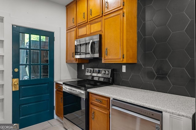 3105 Woodlawn Ave, Columbus, GA 31904 - kitchen with stainless steel appliances, light countertops, tasteful backsplash, and brown cabinets