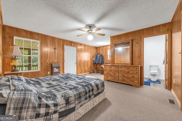 446 Thornton Rd, Washington, GA 30673 - bedroom with wooden walls, carpet, a textured ceiling, ceiling fan, and connected bathroom