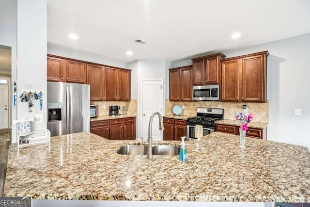 2755 Evan Manor Ln, Cumming, GA 30041 - kitchen with stainless steel appliances, light stone counters, tasteful backsplash, recessed lighting, and a peninsula