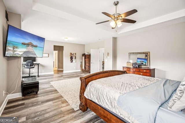 2755 Evan Manor Ln, Cumming, GA 30041 - bedroom with a tray ceiling, wood finished floors, and a ceiling fan
