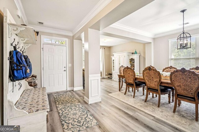 2755 Evan Manor Ln, Cumming, GA 30041 - foyer entrance with light wood-type flooring, a chandelier, and ornamental molding