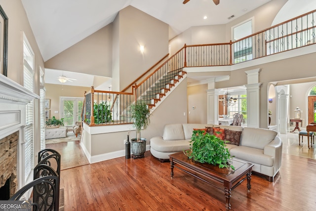 106 April Walk, Mcdonough, GA 30253 - living room with ceiling fan, a towering ceiling, a fireplace, ornate columns, and wood finished floors