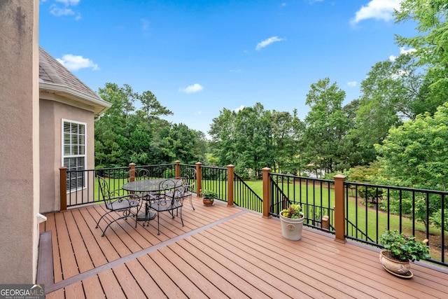 106 April Walk, Mcdonough, GA 30253 - wooden deck featuring outdoor dining area, view of wooded area, and a yard