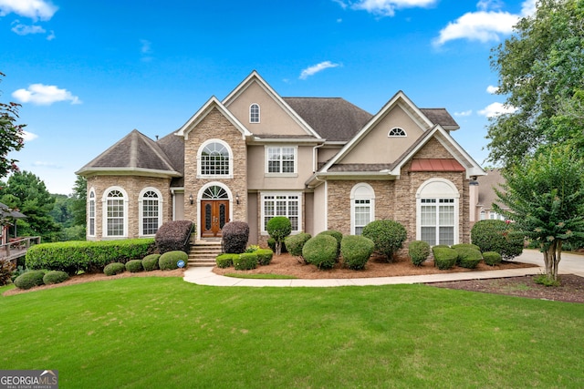 106 April Walk, Mcdonough, GA 30253 - traditional-style house with stone siding, a front yard, stucco siding, and french doors