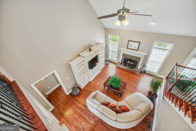 106 April Walk, Mcdonough, GA 30253 - living area featuring a stone fireplace, ceiling fan, high vaulted ceiling, light wood-style floors, and stairs