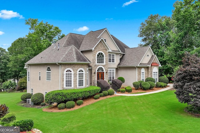 106 April Walk, Mcdonough, GA 30253 - view of front facade featuring stone siding, stucco siding, a front lawn, and a shingled roof